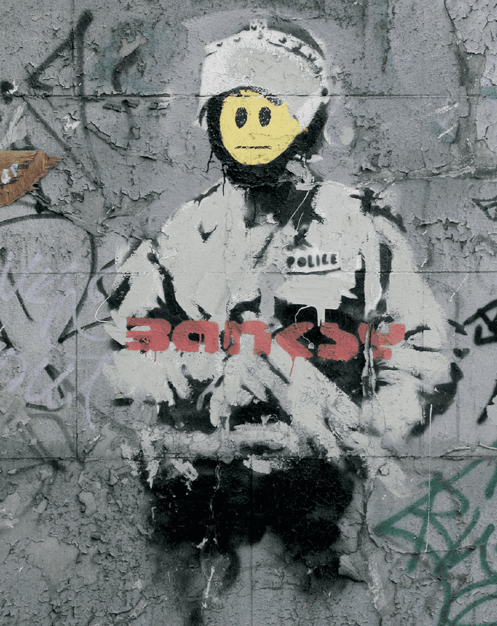 El impacto del enigmático Banksy en el arte urbano emoji emoticon policia 